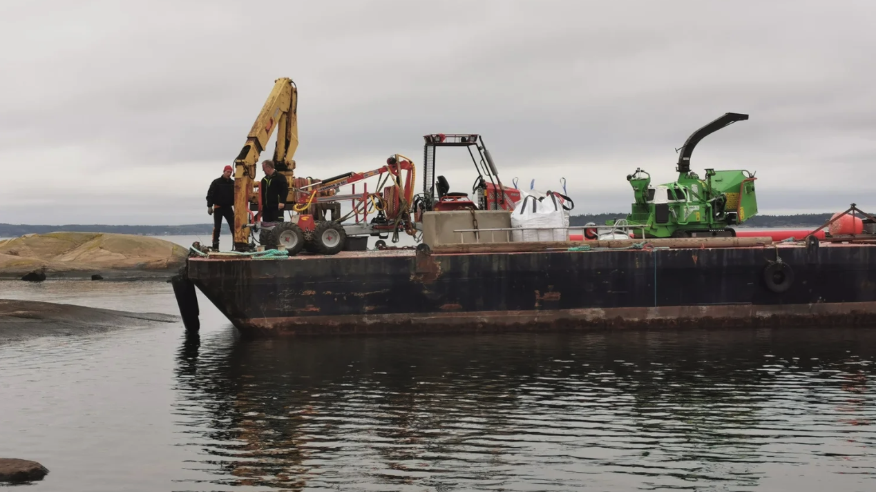 Tungt utstyr på lekter for trefelling